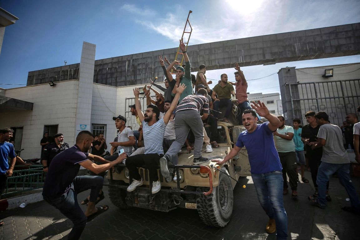 Palestinian fighters ride an Israeli Jeep through Gaza after storming nearby Israeli settlements.