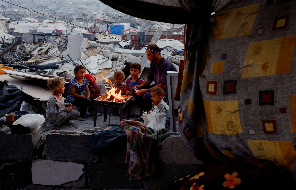 A family shelters among destroyed buildings in Gaza